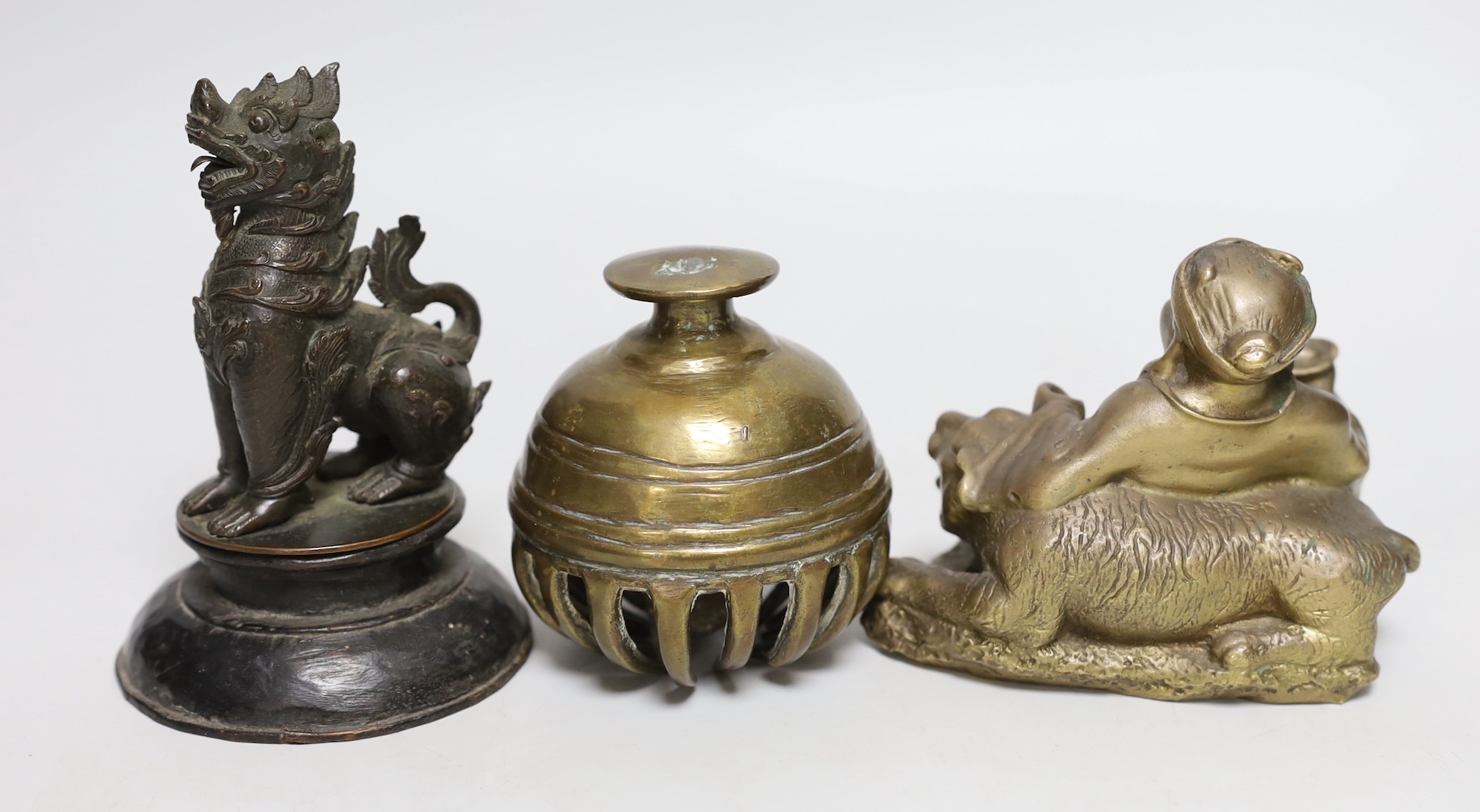 A Chinese bronze seated figure of Budai and tiger together with an Indian elephant bell and a Burmese bronze temple dog